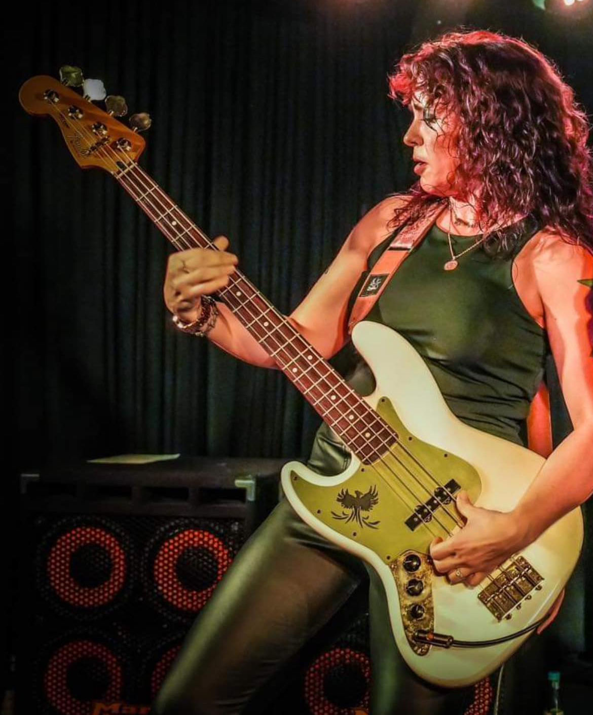 Danielle Nicole, woman in green clothing, playing bass guitar